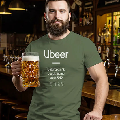 Man in a bar wearing a green t-shirt with 'Ubeer' text, holding a beer mug.