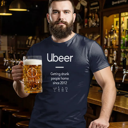 Man in a bar wearing a navy blue t-shirt with 'Ubeer' text, holding a beer mug.