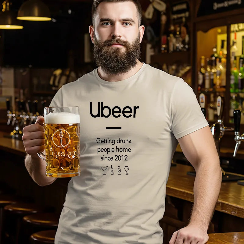Man holding a beer mug wearing a t-shirt with 'Ubeer' branding in a bar setting.