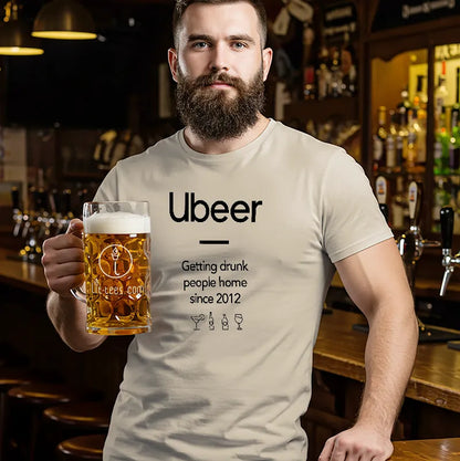 Man holding a beer mug wearing a t-shirt with 'Ubeer' branding in a bar setting.