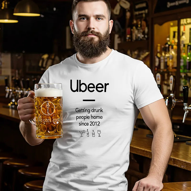 Man holding a beer mug wearing a white t-shirt with 'Ubeer' branding in a bar setting.