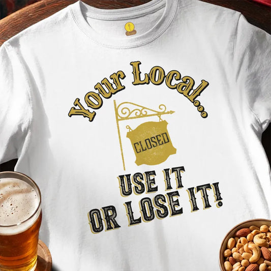 White t-shirt with humorous print saying 'Your Local... use it or lose it' featuring a glass of beer and bowl of nuts on a wooden surface.